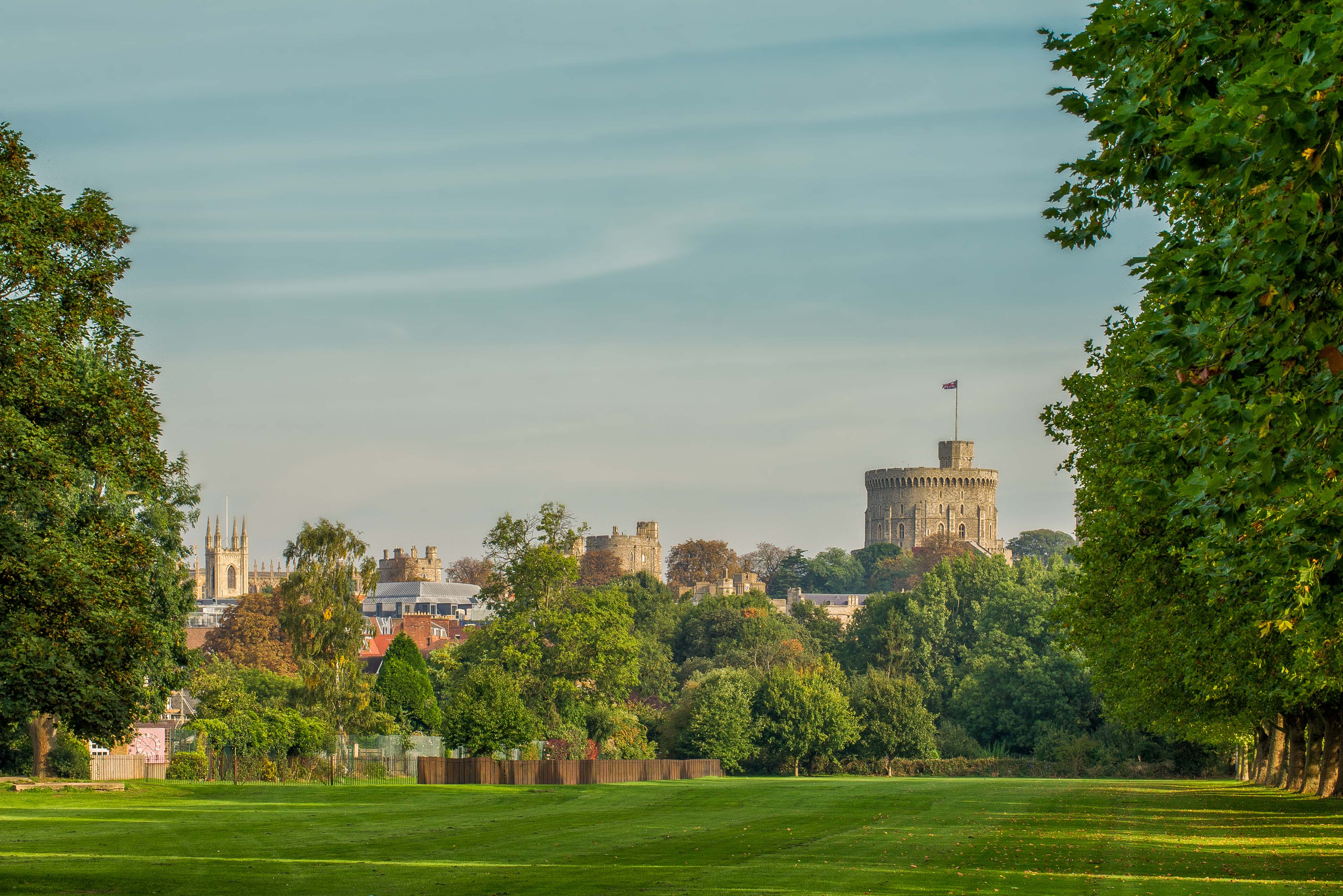 Couple enjoying a picnic in the countryside in Berkshire in South East England with Windsor Castle in the background.