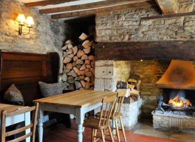 Table by open fire at the Rose & Crown in Shilton
